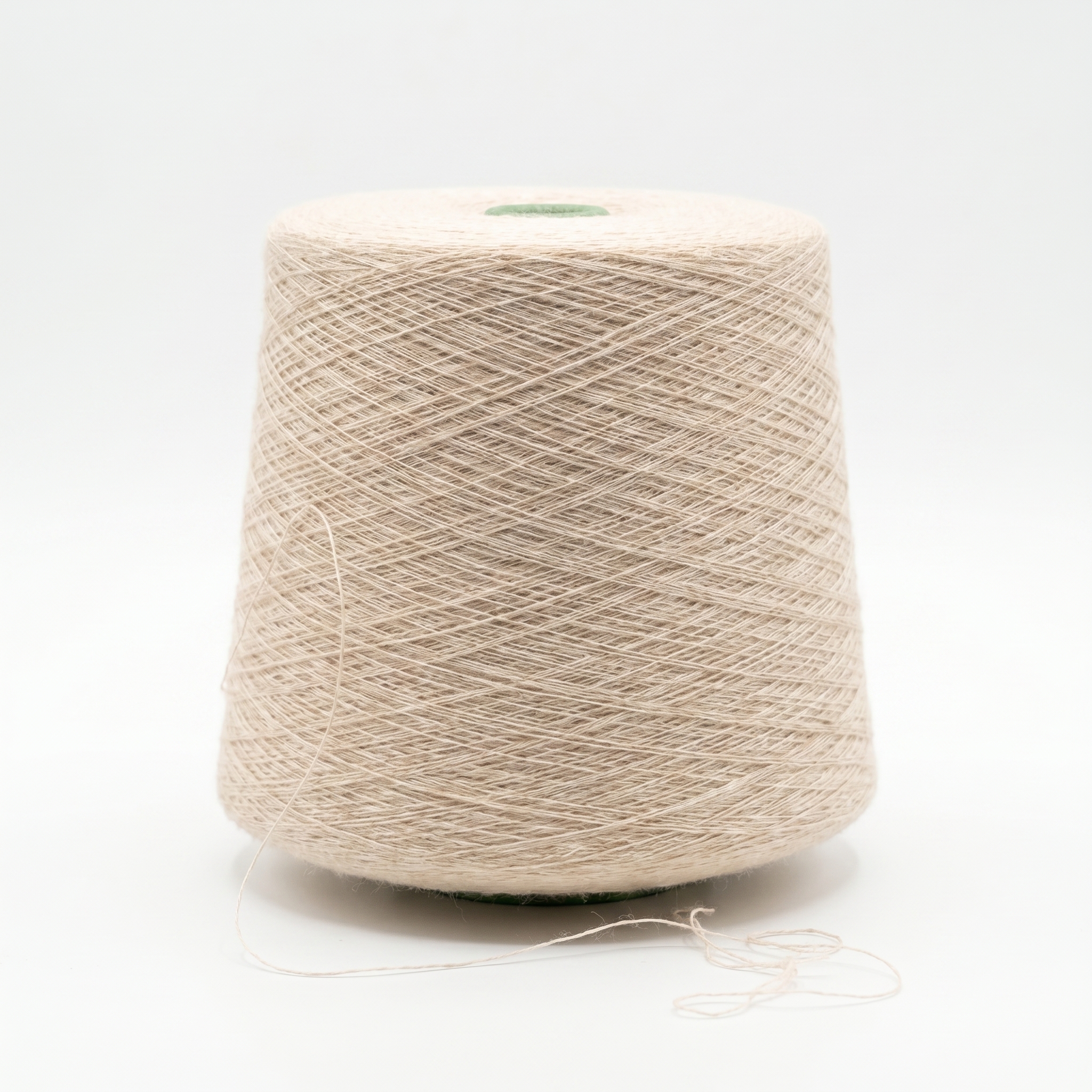 En stor cone med lyst beige garn på en hvid baggrund.