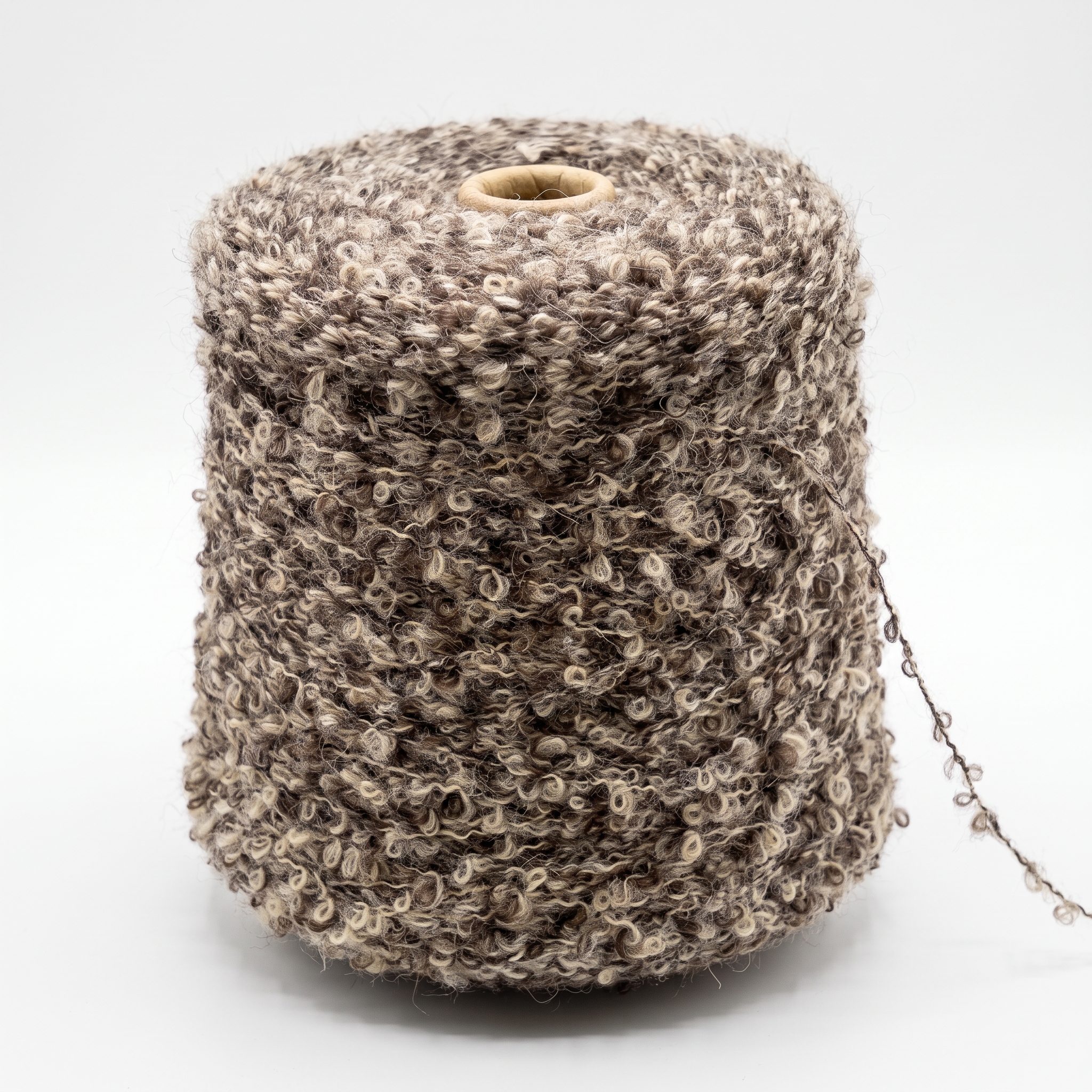 En cone med boucle-garn i brune og beige farver.