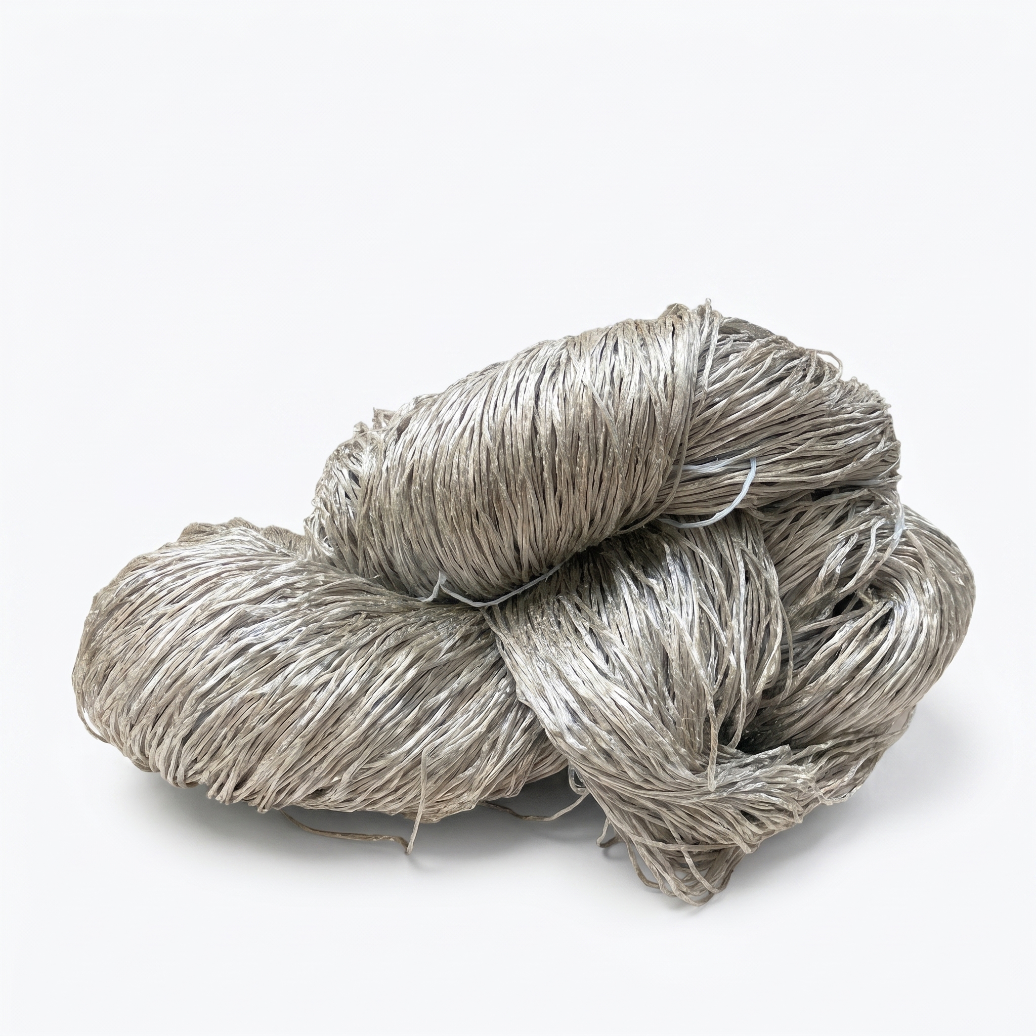 Et stort, løst bundt af gråbeige fibrøst materiale på en hvid baggrund.