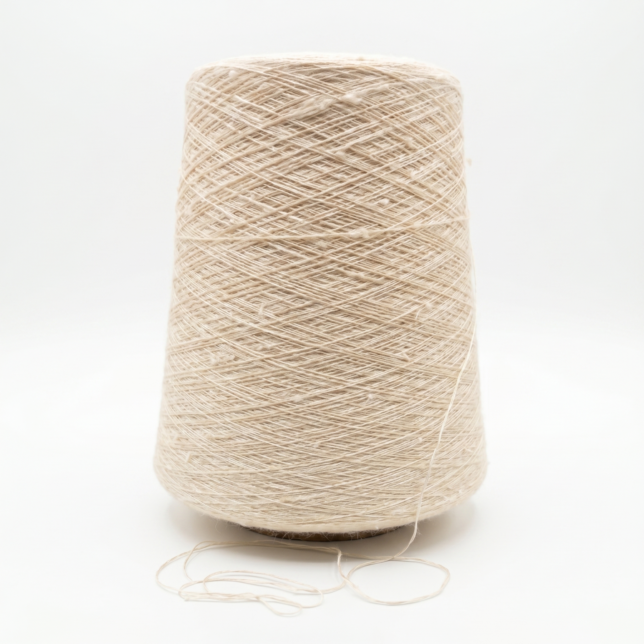 En stor cone med lys beige, tekstureret garn på en hvid baggrund.