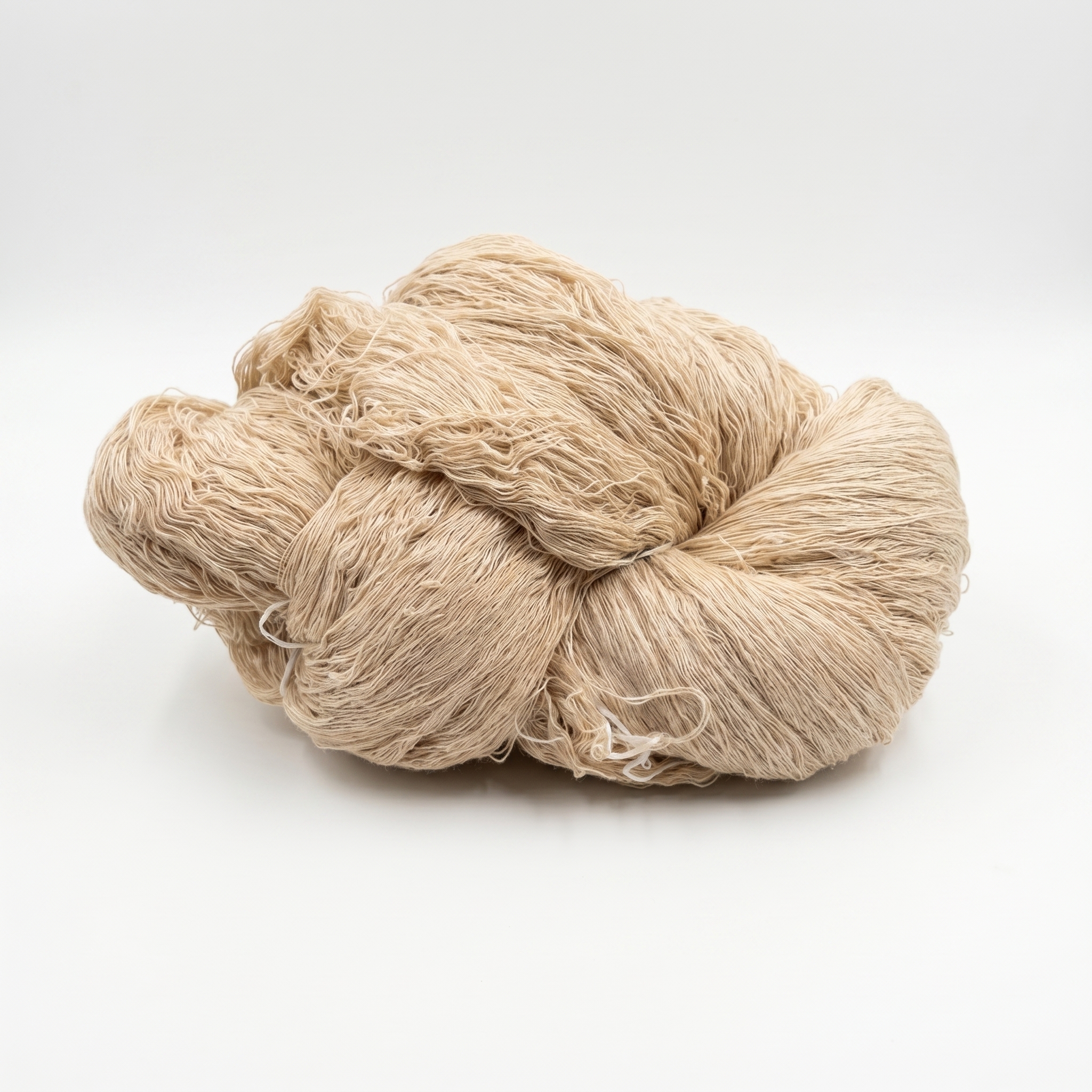 Et fed af lyst beige, fint garn på en hvid baggrund.