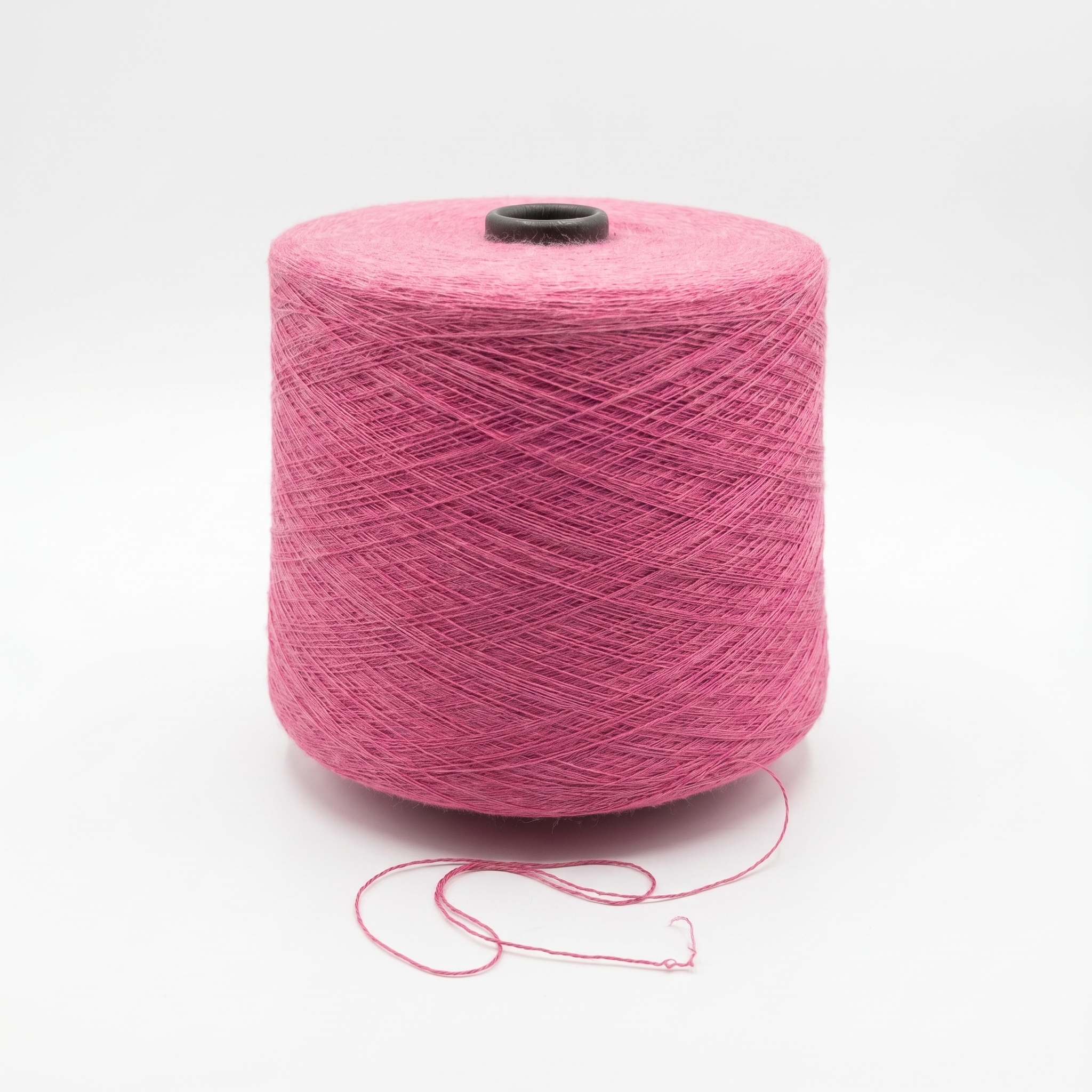 En cone med lyserødt garn på en hvid baggrund.