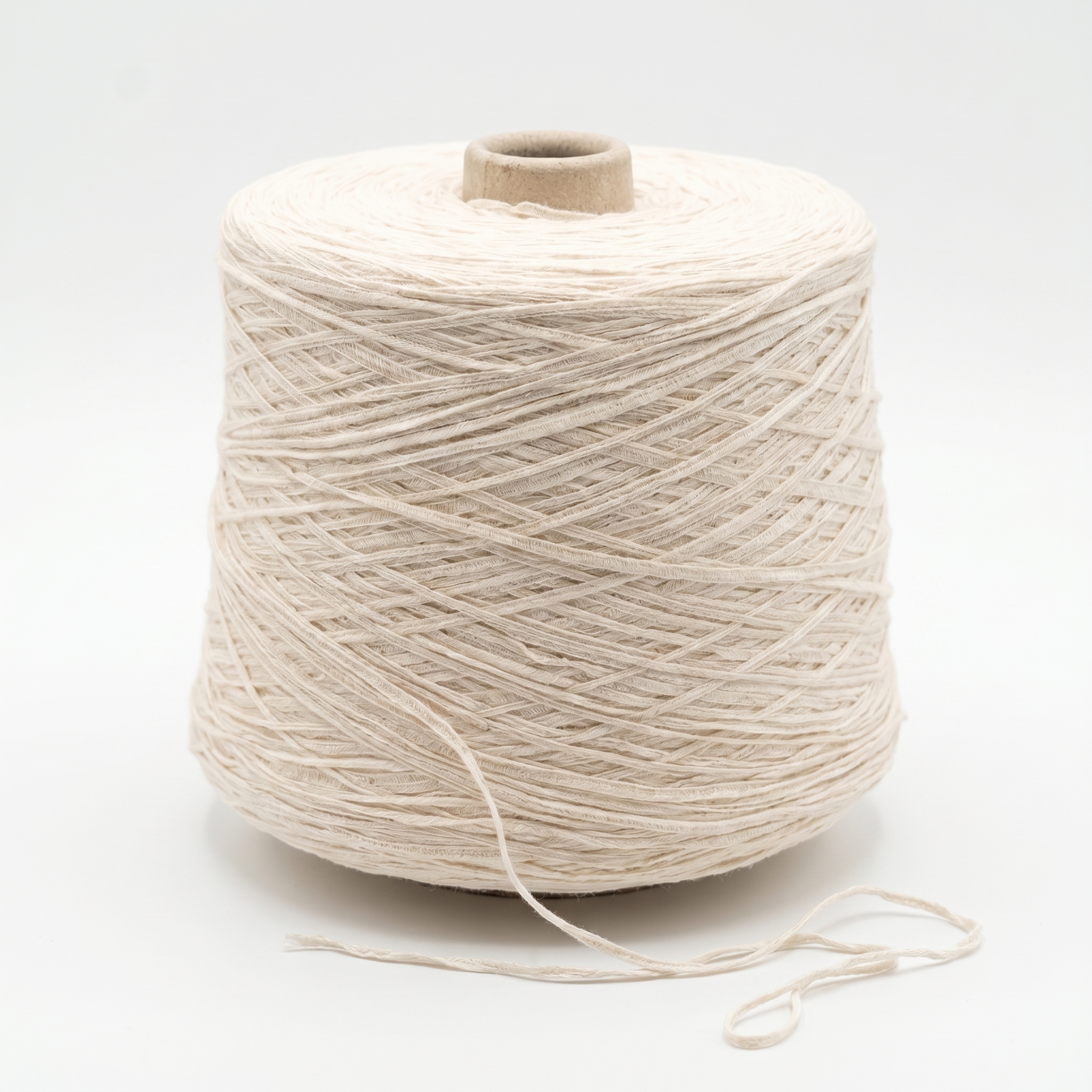 En stor cone af lyst beige garn er viklet tæt, med en løs tråd hængende foran på en hvid baggrund.
