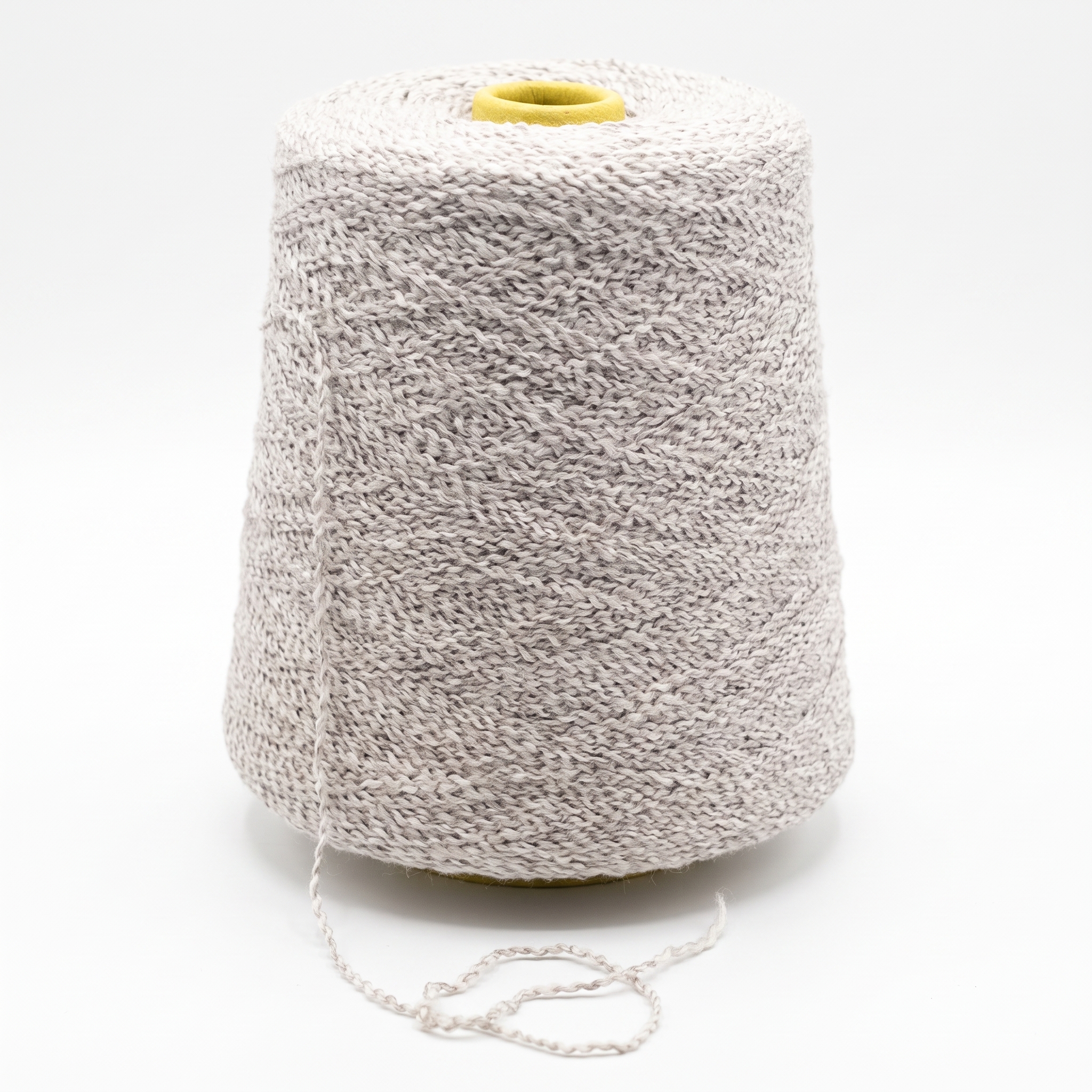 En stor cone med lyst, tekstureret garn, med en løs tråd og en gul top, på hvid baggrund.