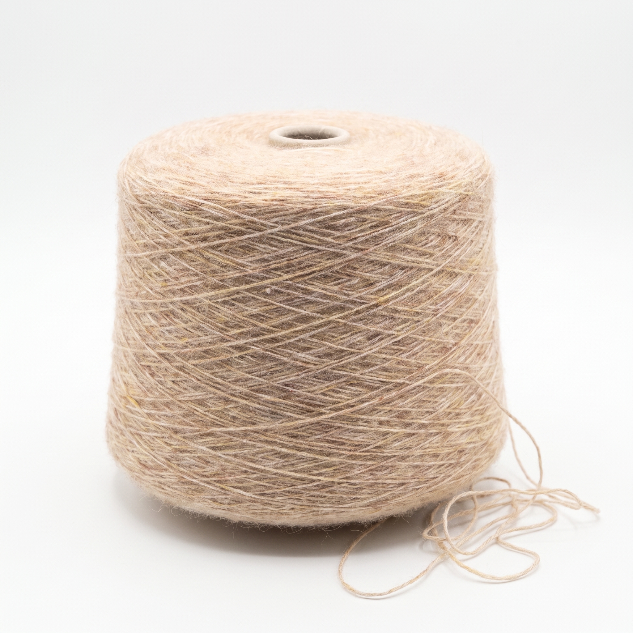 En stor cone med beige garn står på en hvid baggrund med en løs trådende ved bunden.