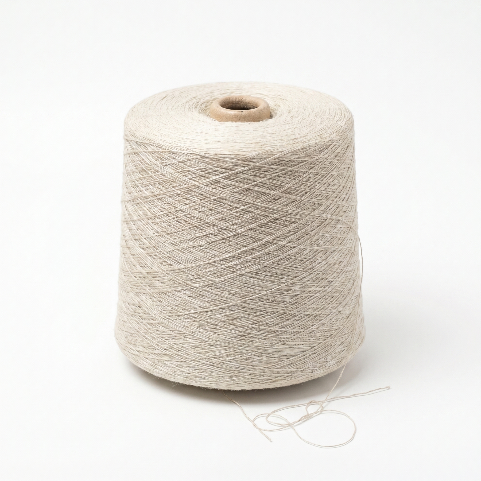 En stor cone af lyst beige garn på en hvid baggrund.