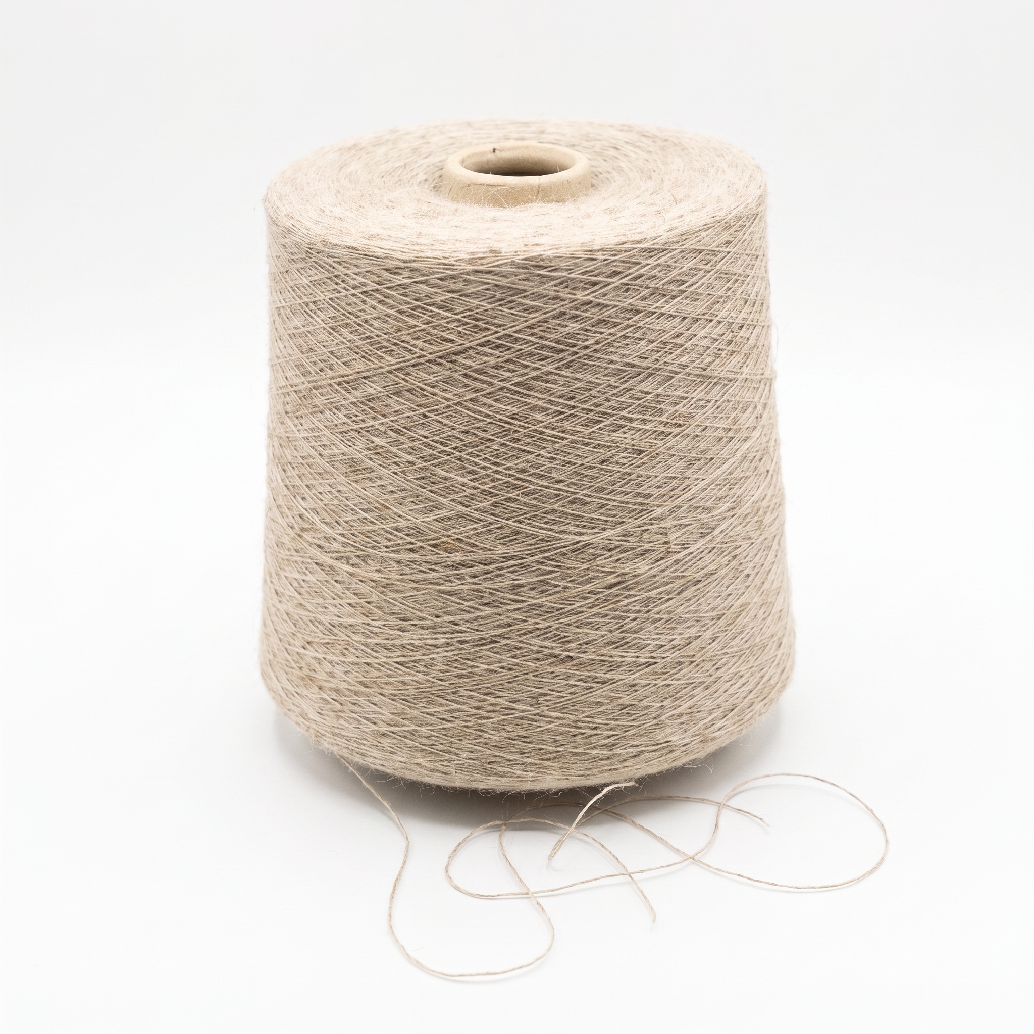 En stor cone af lyst beige garn står på en hvid baggrund med en løs tråd forneden.