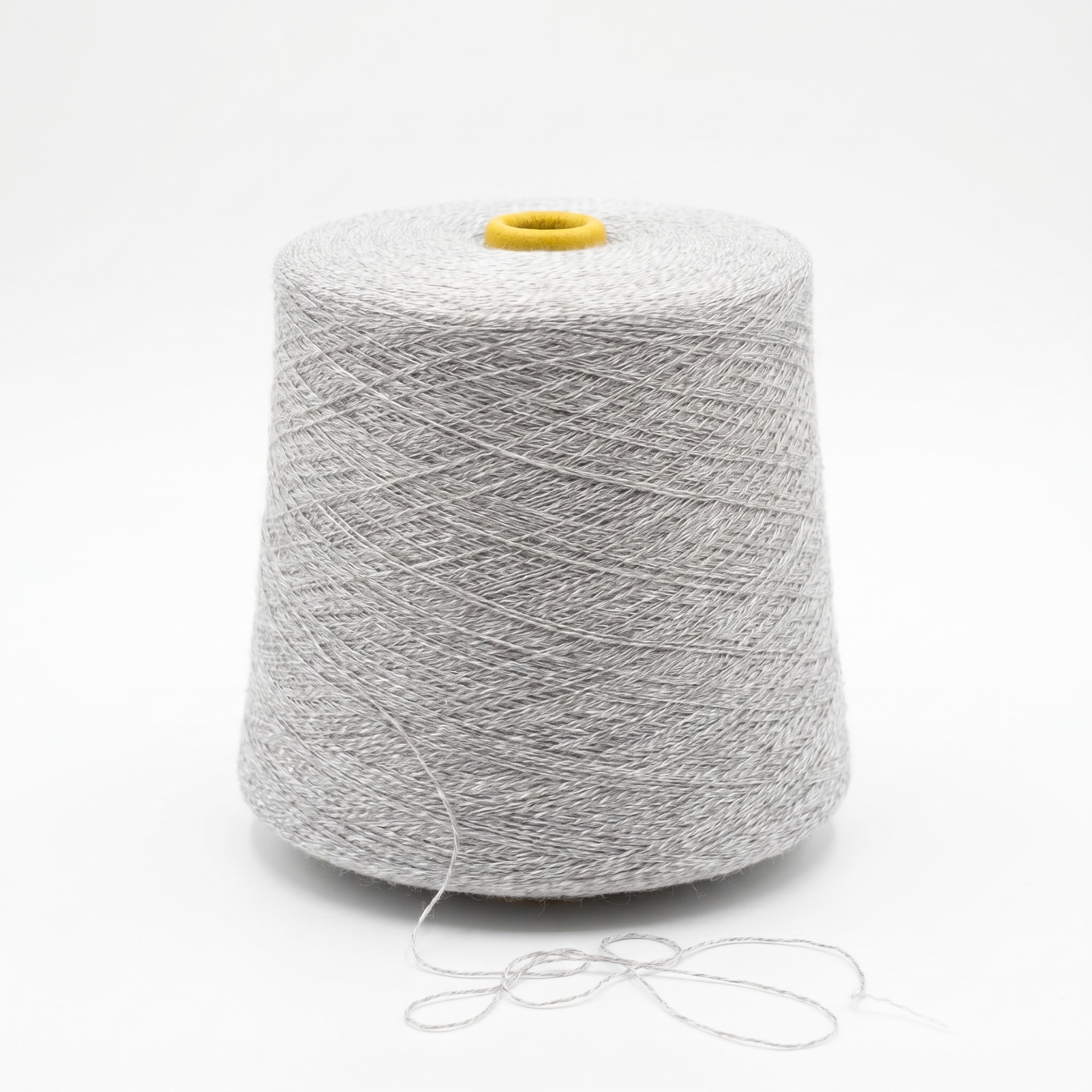 En stor cone med lyst gråt garn på en hvid baggrund.