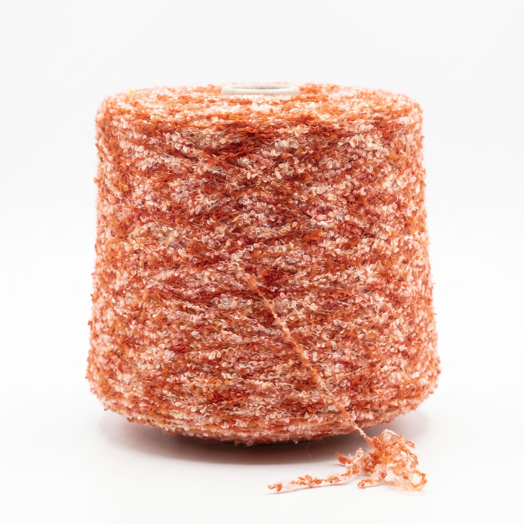 En cone med tekstureret bouclégarn i orange og hvide nuancer.