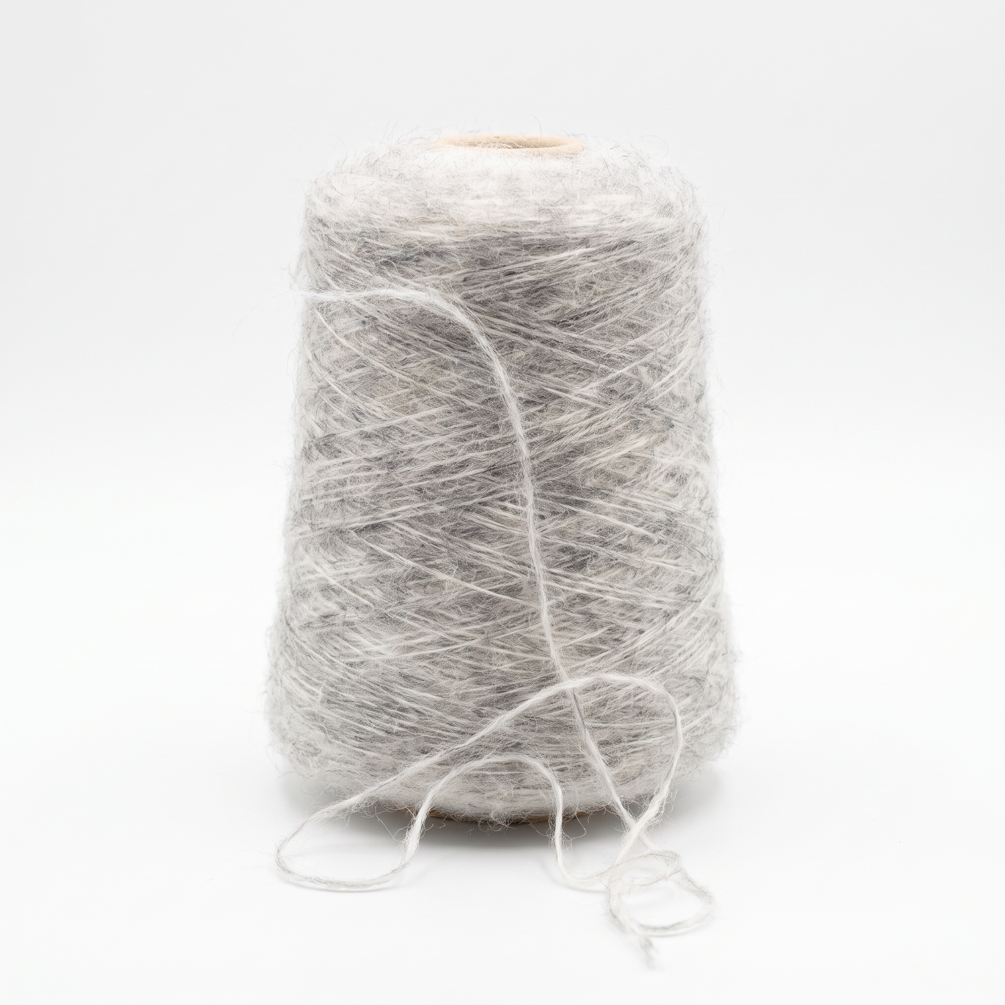 En cone med lyst, gråt og fluffy garn på en hvid baggrund.