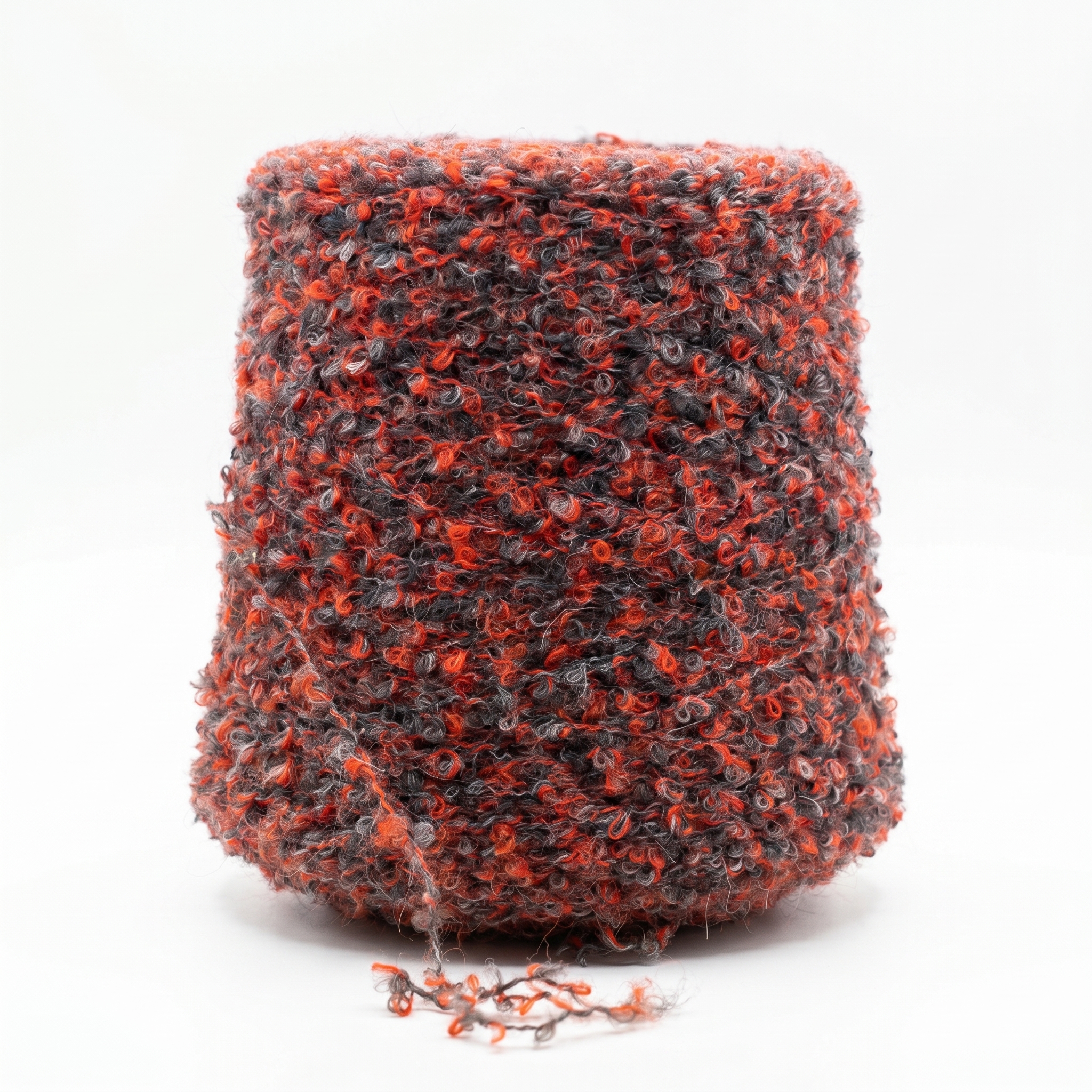 En stor cone med bouclégarn i orange og grå nuancer.