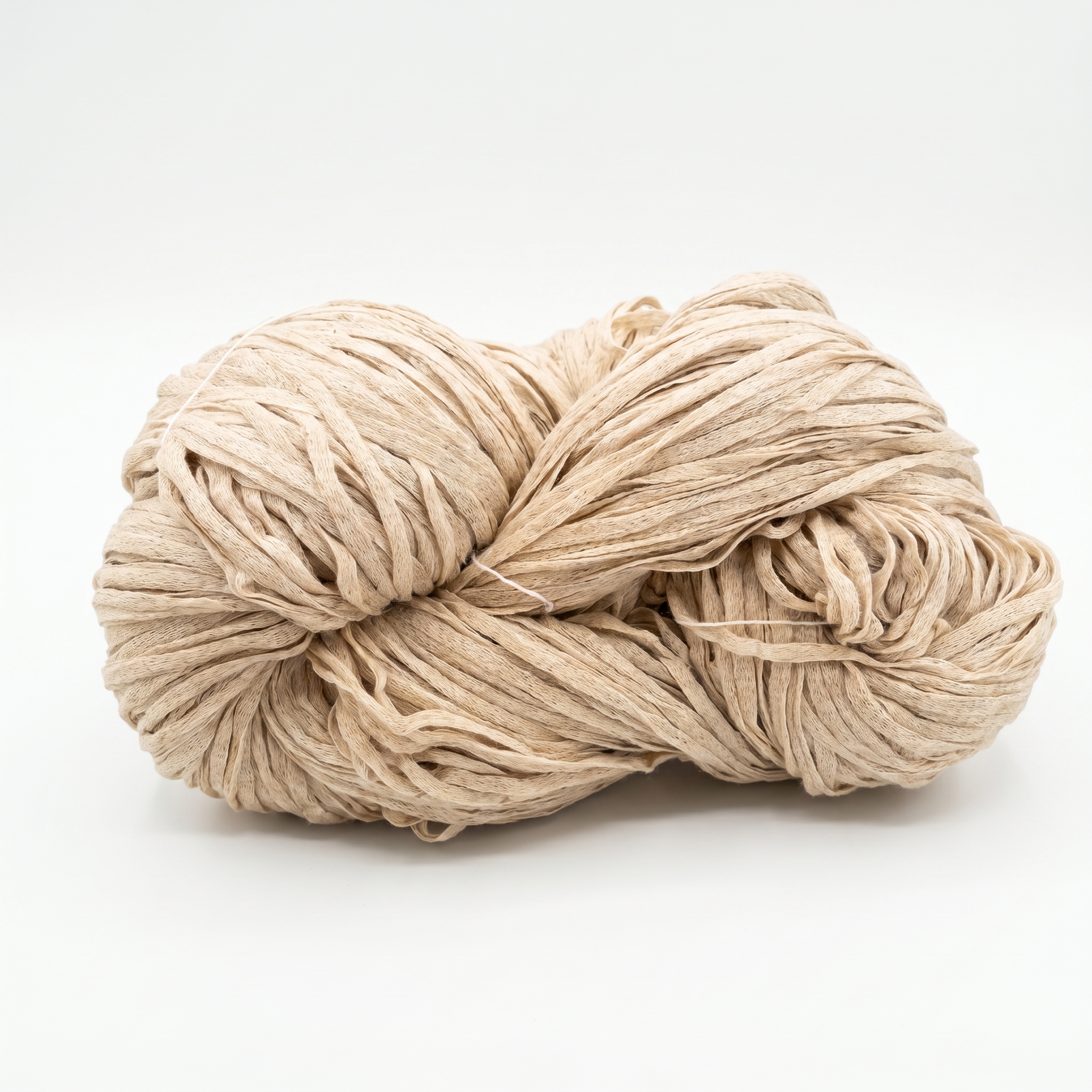 En nøgle af beige garn, der ligner raffia, præsenteret på en hvid baggrund.