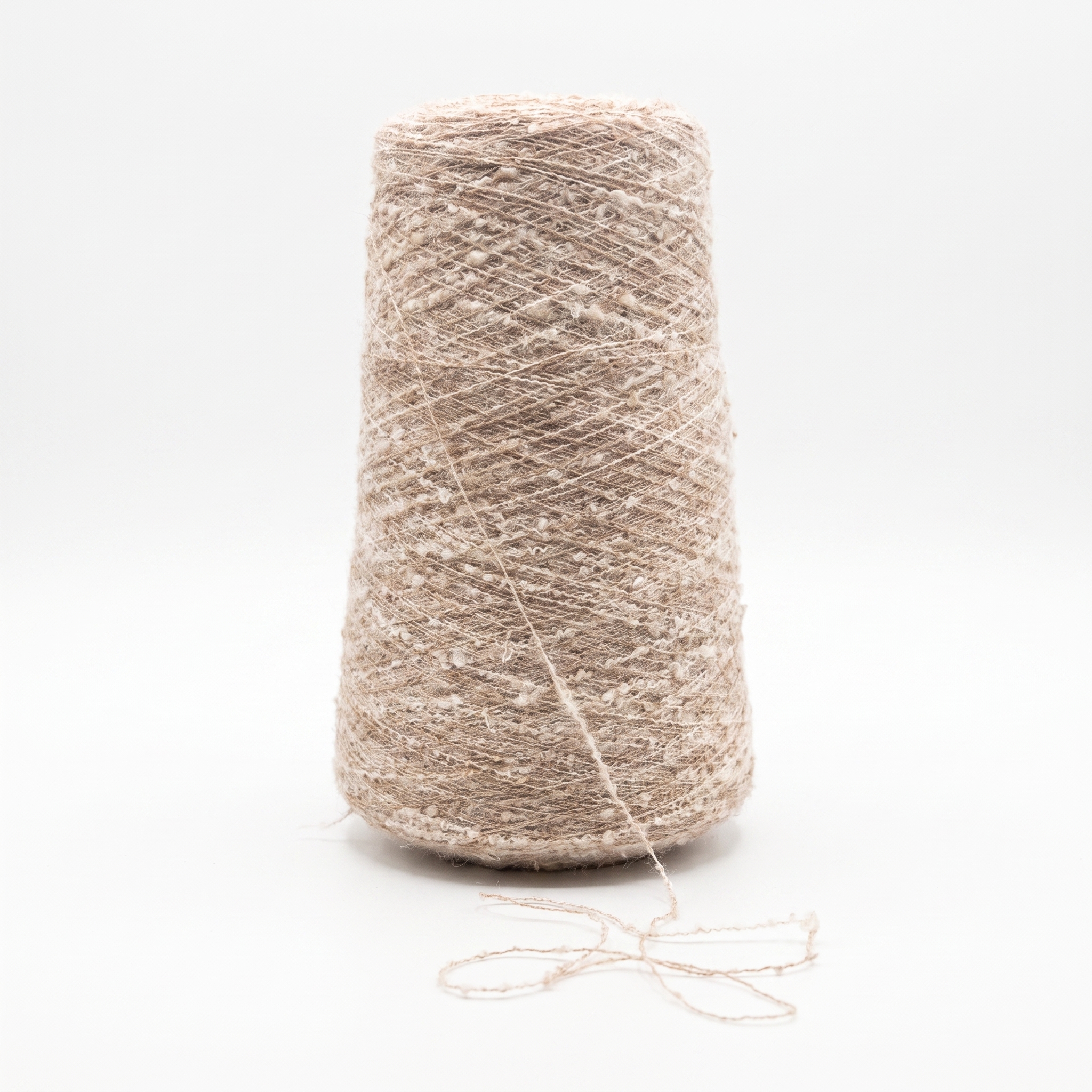En cone med beige, tekstureret garn på en hvid baggrund.